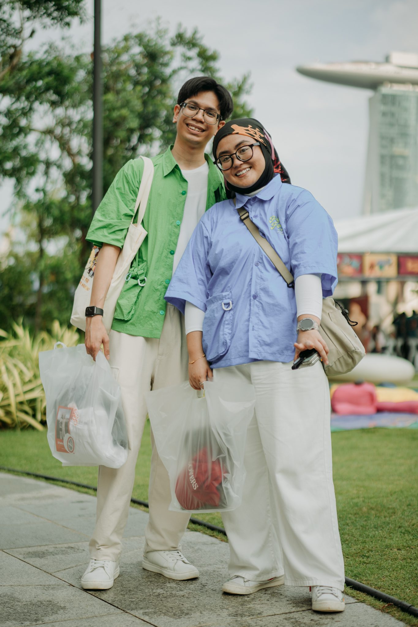 Two shoppers with bags at Me-You Market, Marina Bay Sands behind them